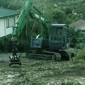 Green excavator clearing land